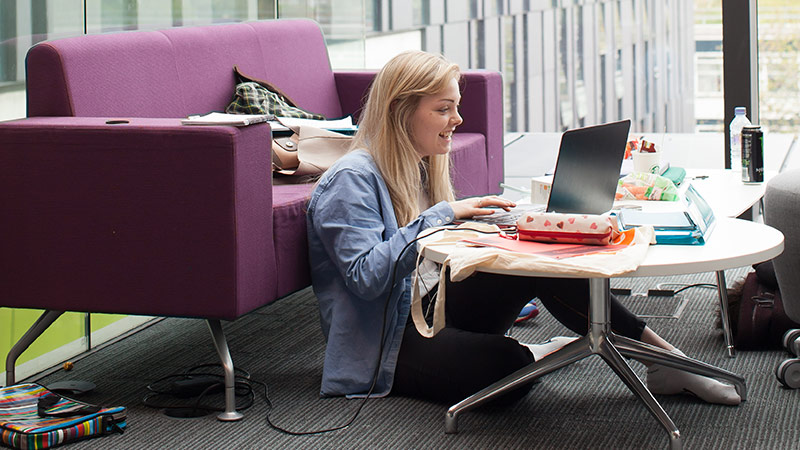 Student relaxing in the John Henry Brookes Building