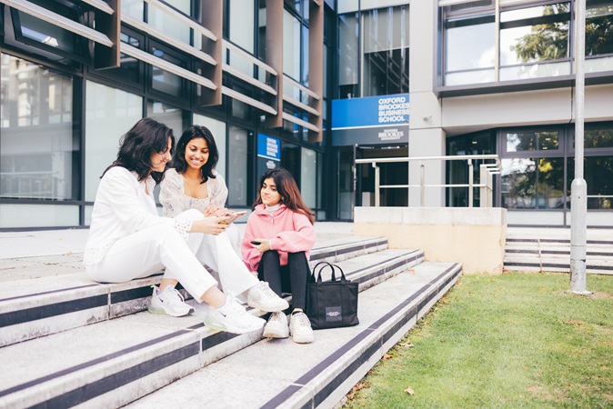 Female student discussing hospitality management with fellow students