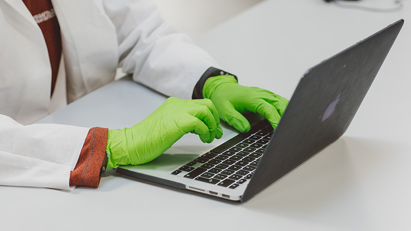 Student typing notes on a laptop in the lab