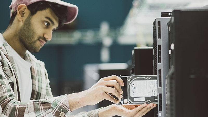 Student replacing a hard drive in a computer